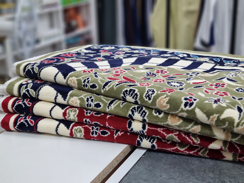 Rail of men's thobes in beige, white and grey, neatly hung on black hangers