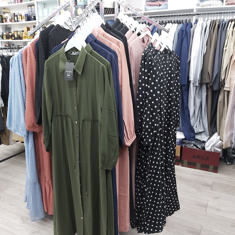 Racks of long modest dresses in olive green, pink and black-and-white polka dot